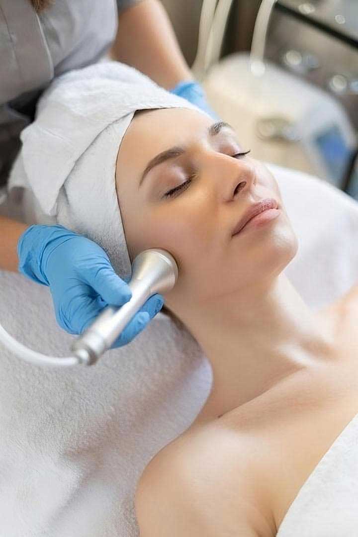 Woman Receiving Facial At Dermatology Aesthetic Clinic With Specialized Machine — Bespoke in Southport, QLD