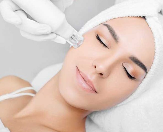 Woman Receiving Facial Treatment At Aesthetic Clinic Using Specialized Device — Bespoke in Southport, QLD